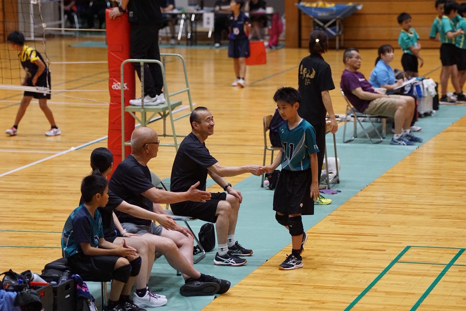 第9回中村杯でベンチの指導者とハイタッチする粟野男子選手